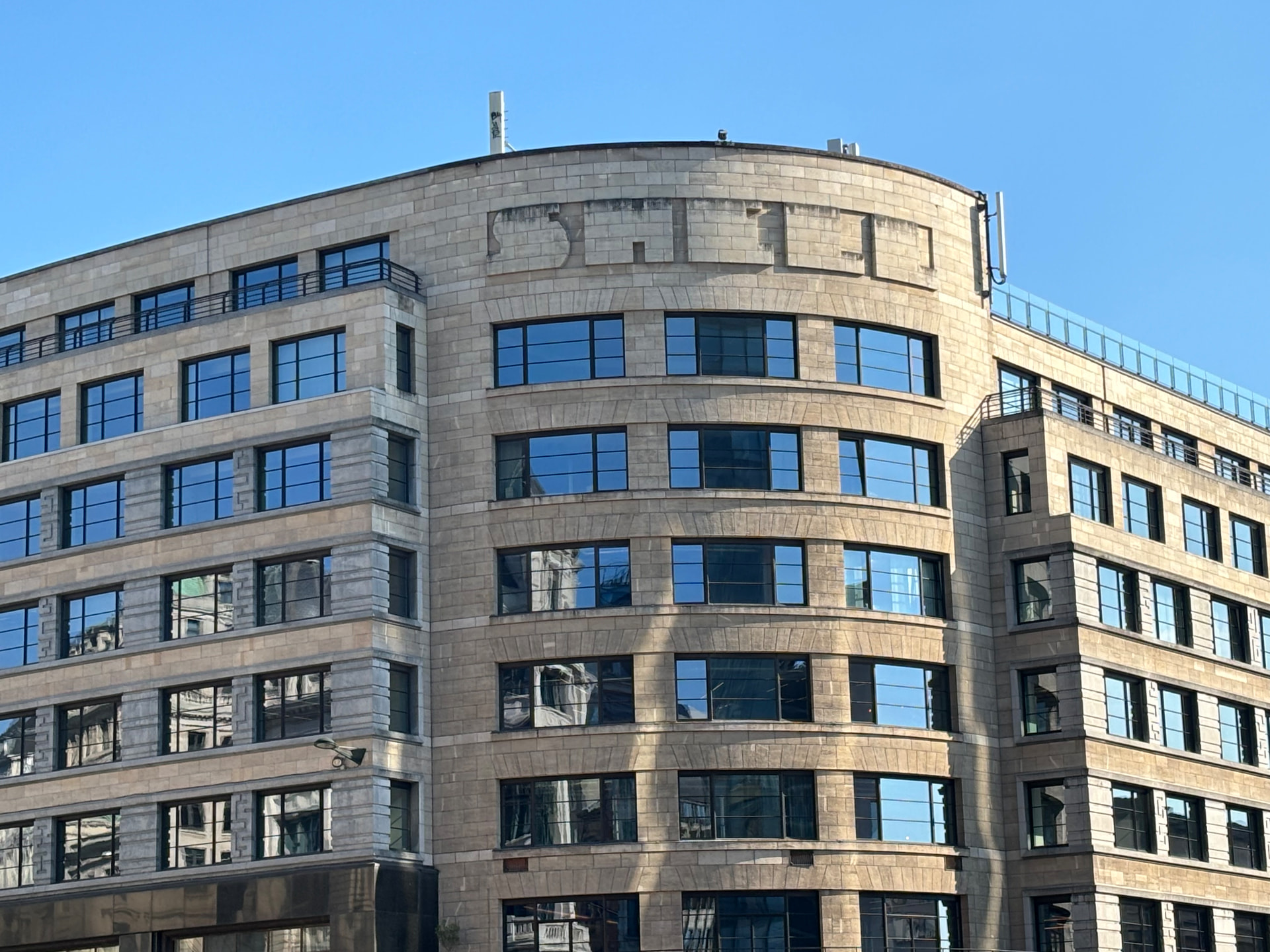 Façade de Central Gate, ancien immeuble Shell à Bruxelles, inscription SHELL encore visible en relief sur la pierre, ciel bleu